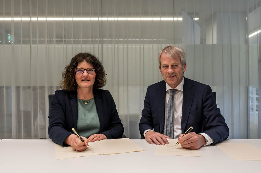 Voorzitter van het College Gerechtelijk Deskundigen van het NRGD Eric Bakker en directeur NFI Annemieke de Vries ondertekenen een samenwerkingsovereenkomst over combineren van examens.